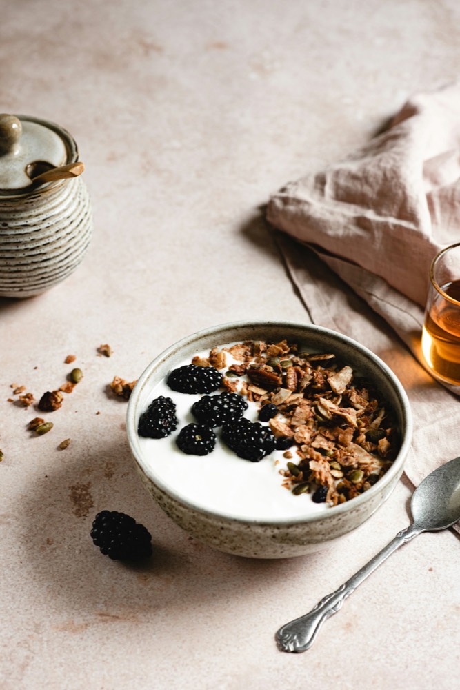 A bowl of yogurt with granola and berries